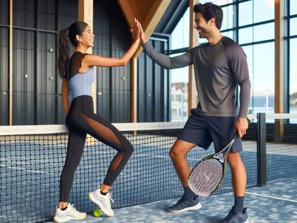 A couple high fives at a norwegian indoor padel court smiling